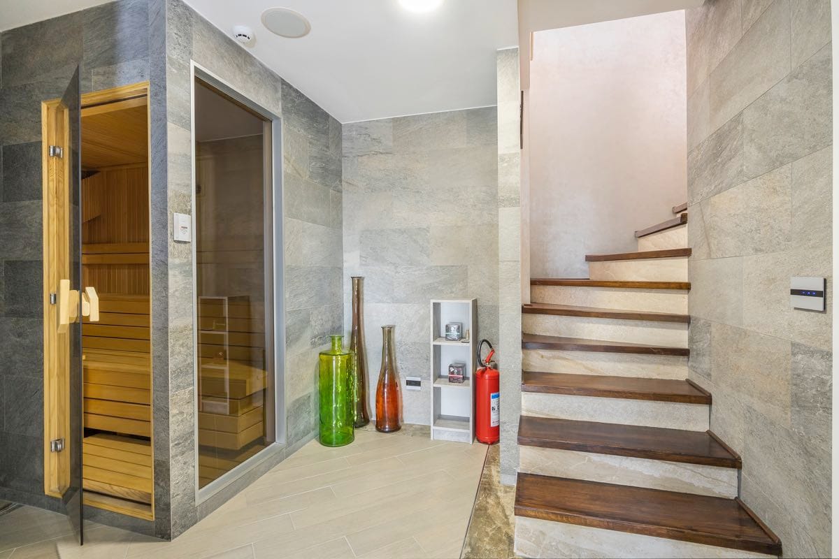 Savremena sauna i drveno stepenište u enterijeru vile u Budvi, Crna Gora, obloga od kamena i stilizovan dekor.