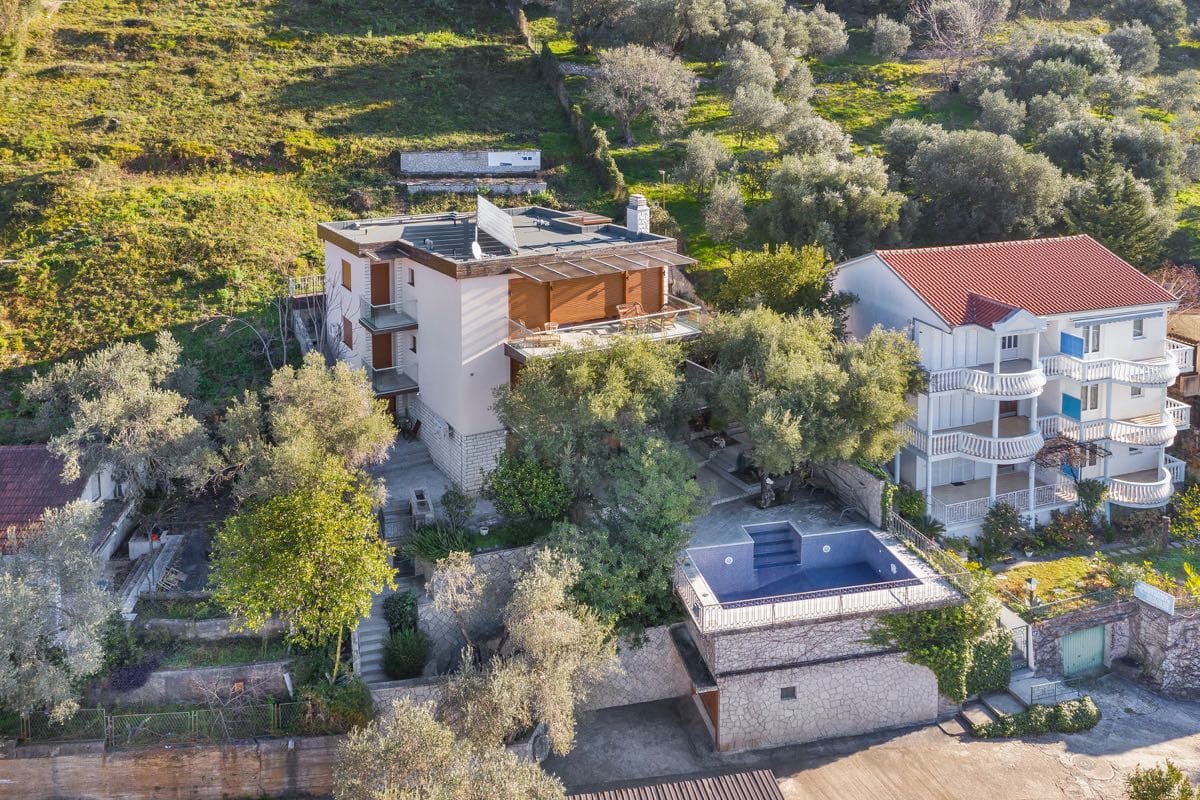 Vila u Budvi, Crna Gora: pogled na kuću sa terasama, maslinjakom i privatnim bazenom na padini planine.