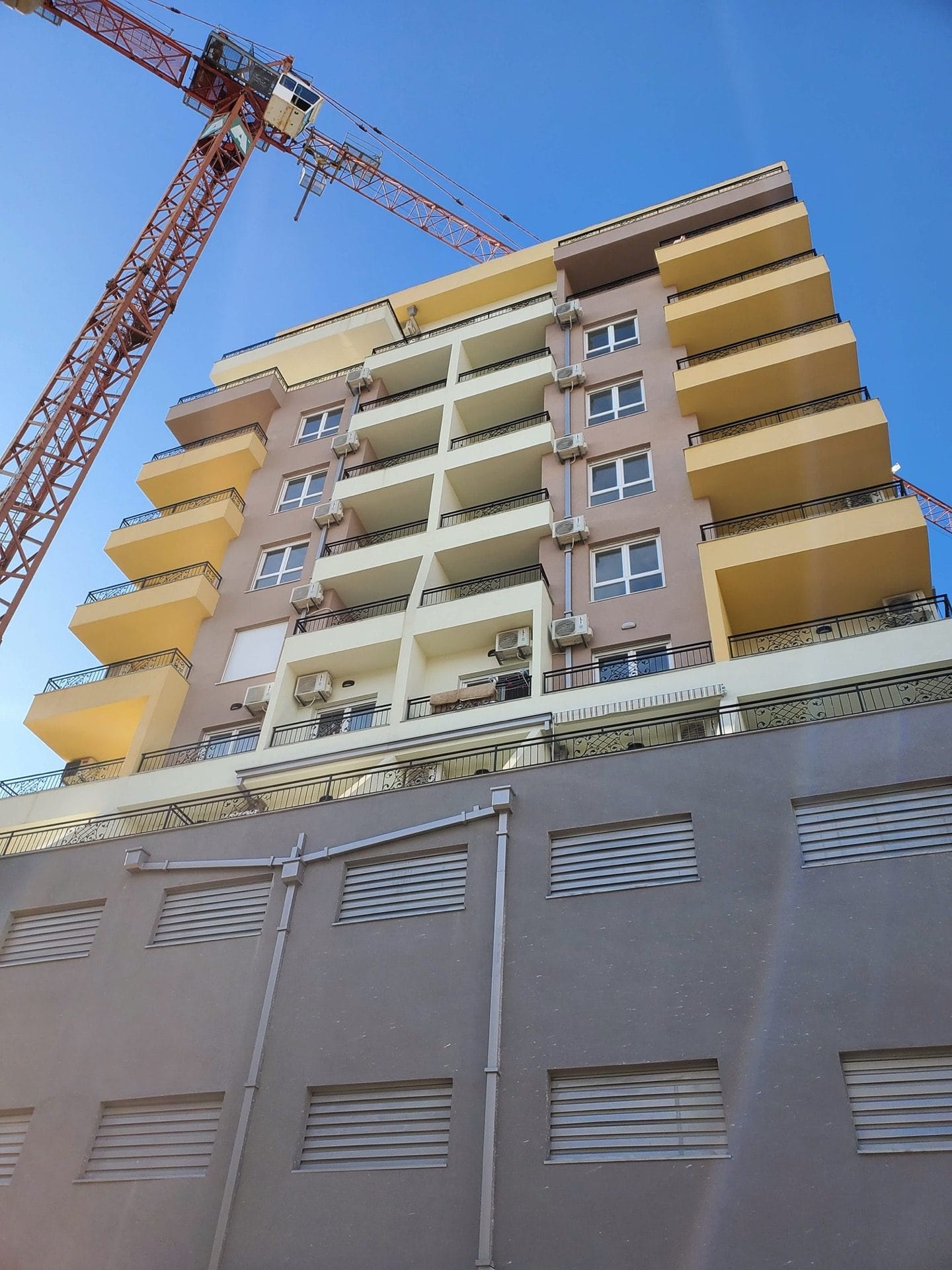 Residential complex under construction in Budva, Montenegro: a modern multi-story building with balconies and facade glazing.