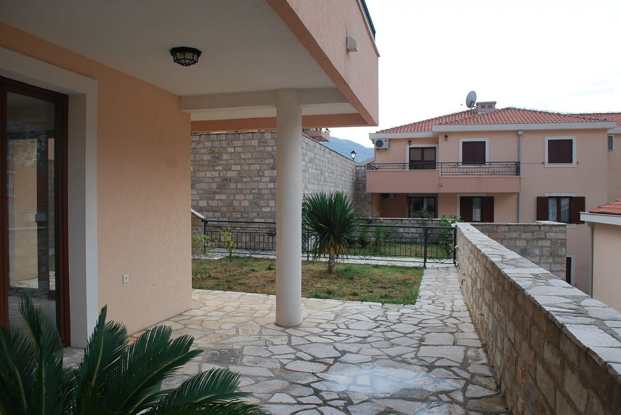 Prostrana terasa sa kamenim podom i pogledom na baštu u stanu, grad Risan, Crna Gora.