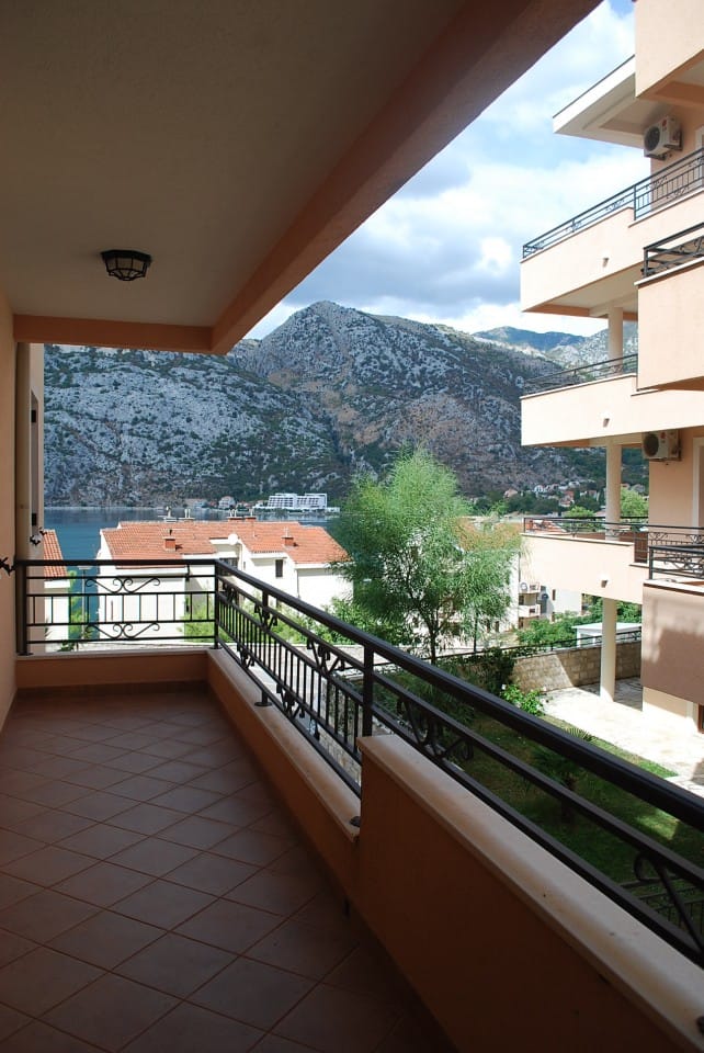 Prostran balkon s pogledom na Bokokotorski zaliv i planine u stanu u gradu Risan, Crna Gora.