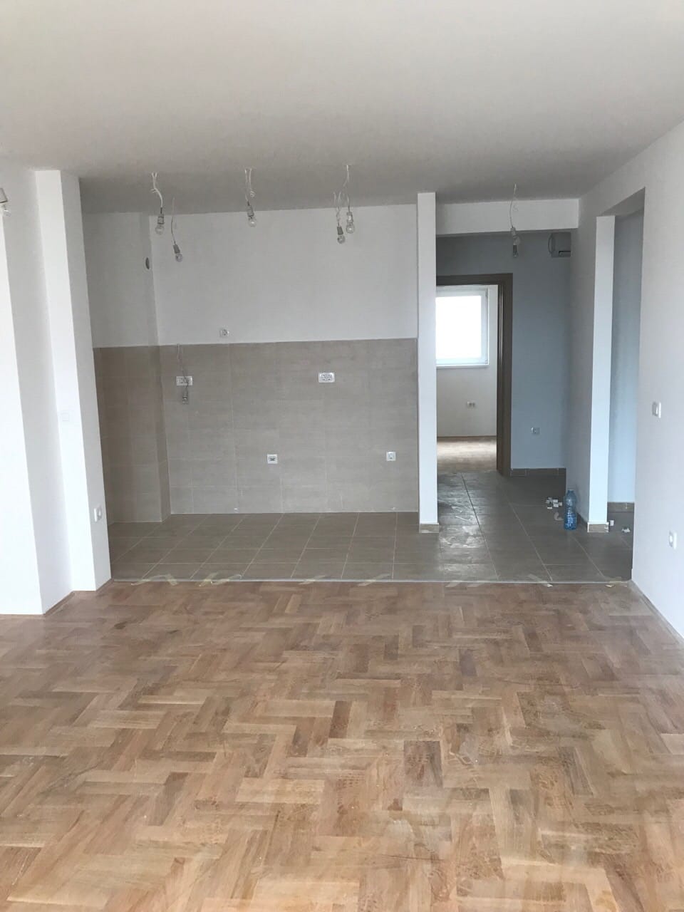 Kuhinja sa završnom obradom i parketom u stanu na prodaju u Budvi, Crna Gora. Prostor bez nameštaja sa zonom za kuvanje.