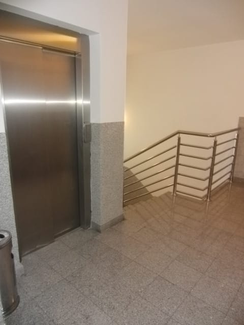Moderan lift i stepenišni podest sa oblogom od kamena u stambenom kompleksu u gradu Budvi, Crna Gora.