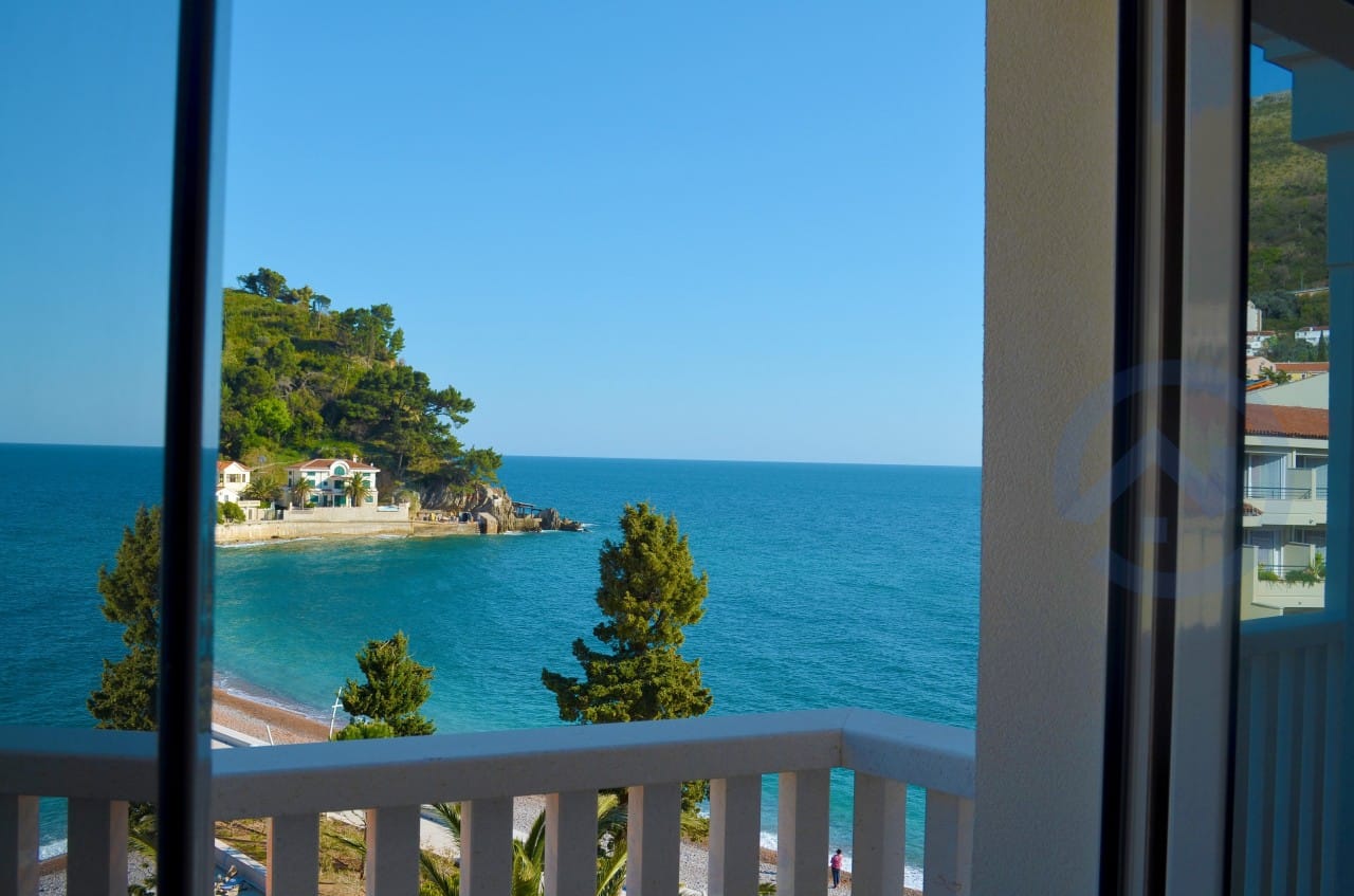 Pogled sa balkona stana u Petrovcu, Crna Gora: panorama Jadranskog mora, plaže i slikovitog zelenog rta.