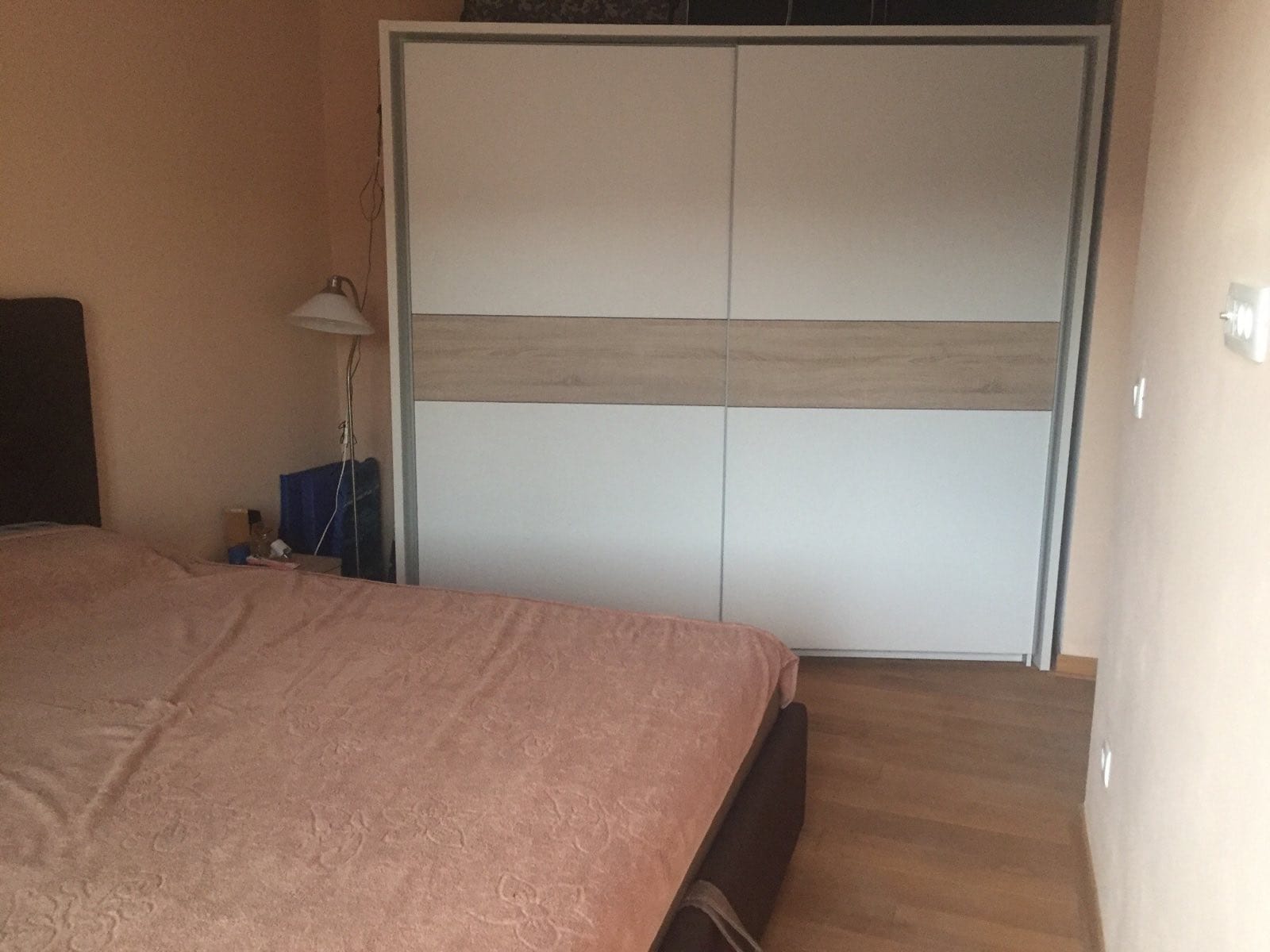 Chambre dans un appartement à Petrovac, Monténégro : lit double, grande armoire encastrée et parquet.