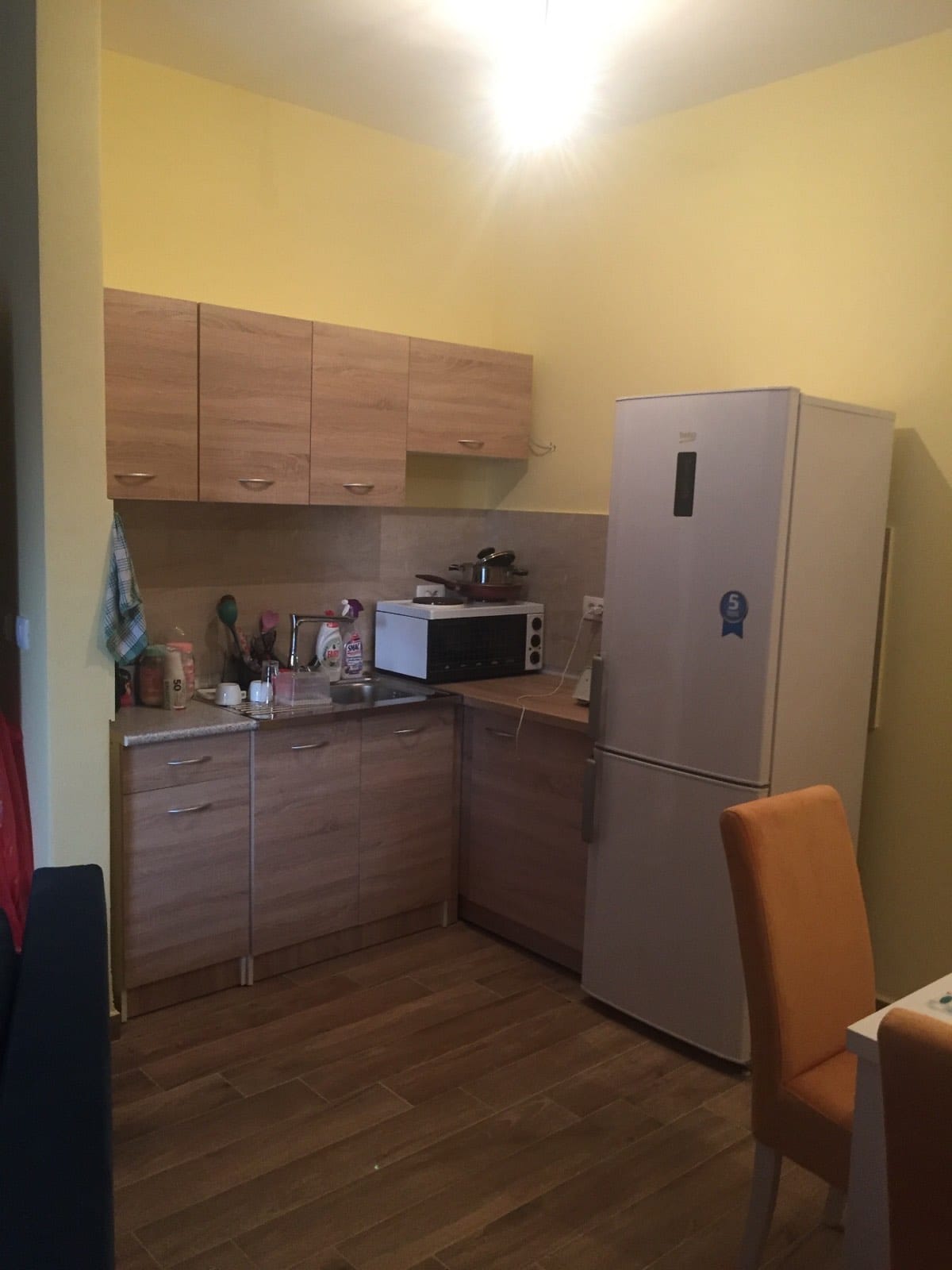 Cuisine compacte avec mobilier en bois et réfrigérateur dans un appartement à vendre à Petrovac, Monténégro.