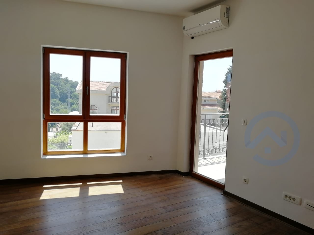 Salon lumineux avec parquet, accès au balcon et vue sur les montagnes dans un appartement à Petrovac, Monténégro.