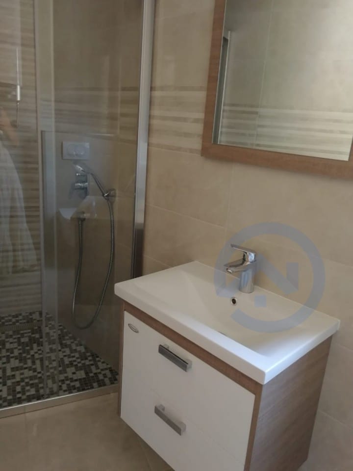 Salle de bains moderne avec cabine de douche et meuble sous vasque dans un appartement, Petrovac, Monténégro.