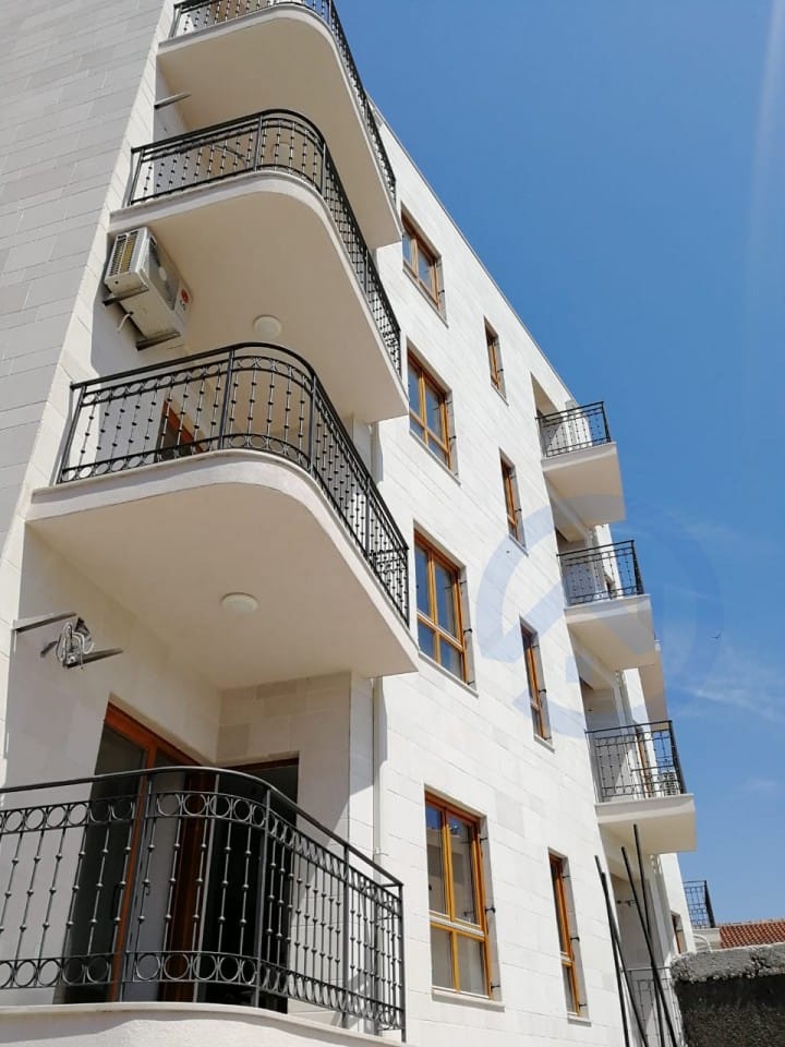 Maison résidentielle moderne avec balcons et garde-corps en fer forgé à Petrovac, Riviera de Budva, Monténégro.