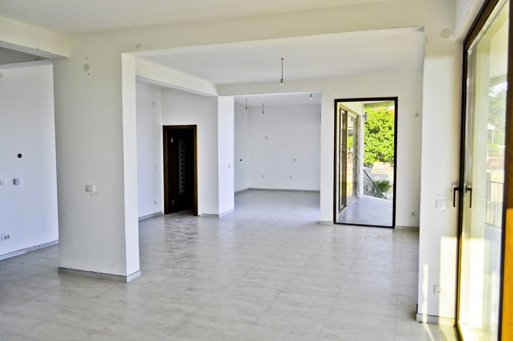 Spacious living room with white finishes and access to the terrace in a villa, Shushan, Montenegro.