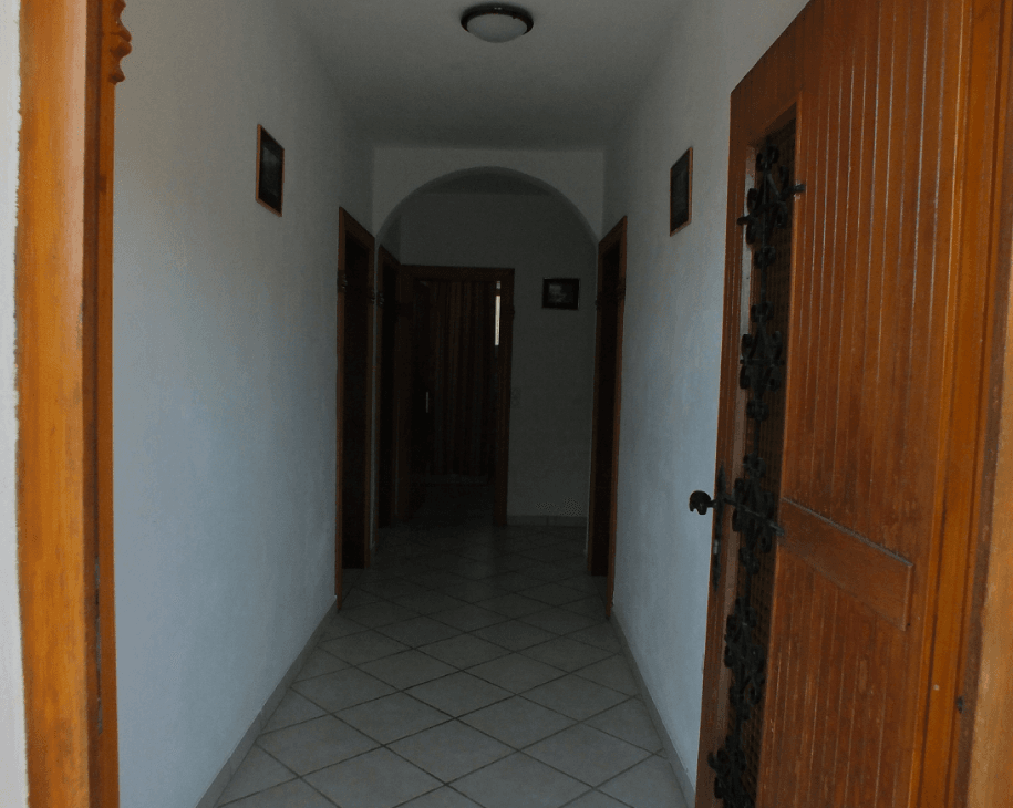 Bright hallway with an arched passage and wooden doors in a house for sale in Bar, Montenegro.
