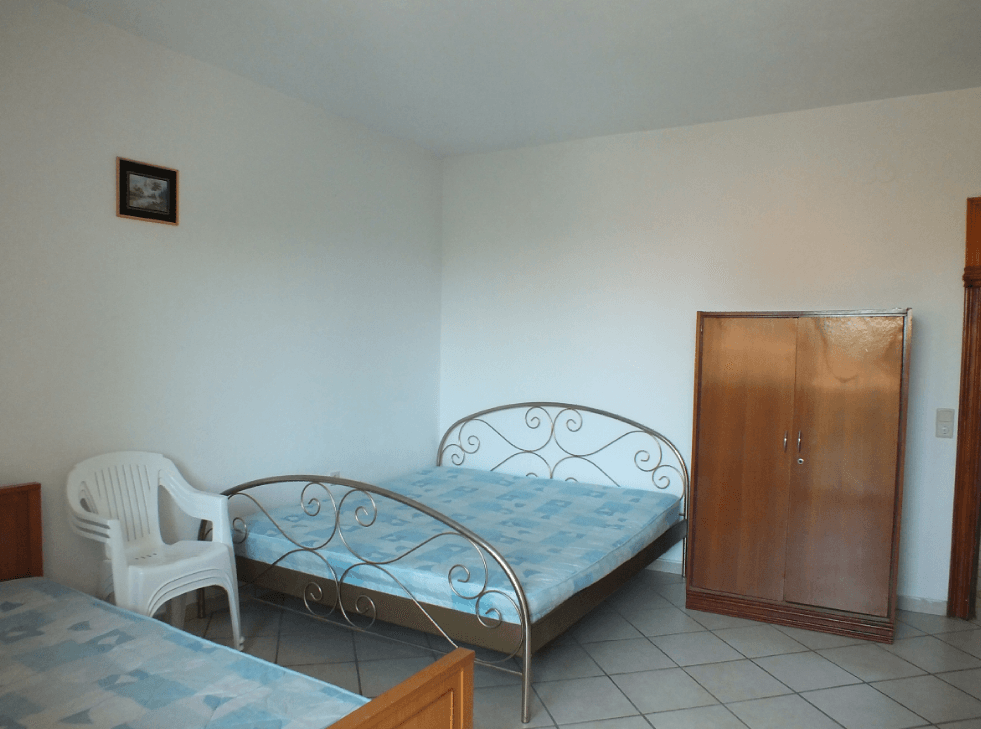 Bedroom in a house in Bar, Montenegro: a double bed with a wrought-iron headboard, a wardrobe, and tiled flooring.