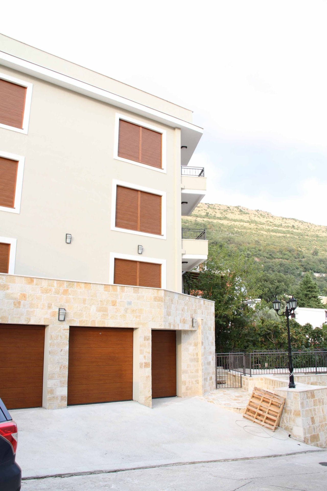 Modern residential building with garages and stone facade cladding in Petrovac, Montenegro.