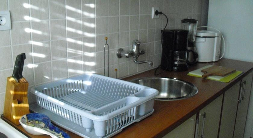 Karadağ, Herceg Novi’deki evde mutfak: tezgah, lavabo, beyaz eşyalar ve iç mekânda fayans backsplash.