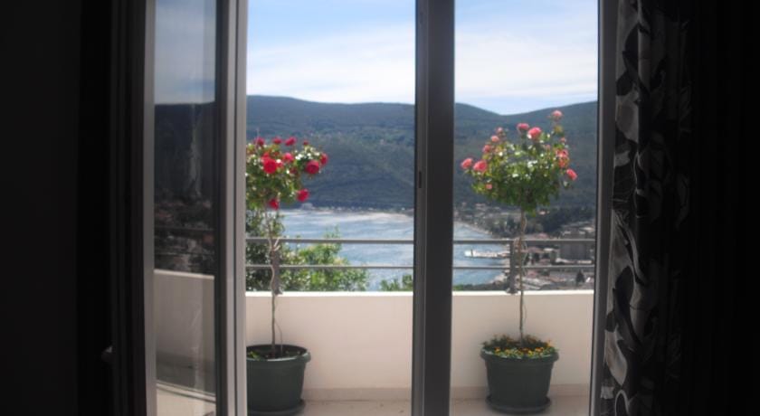 Karadağ, Herceg Novi’deki evde deniz ve dağ manzaralı balkon: saksı çiçekleri olan teras ve panoramik manzara.