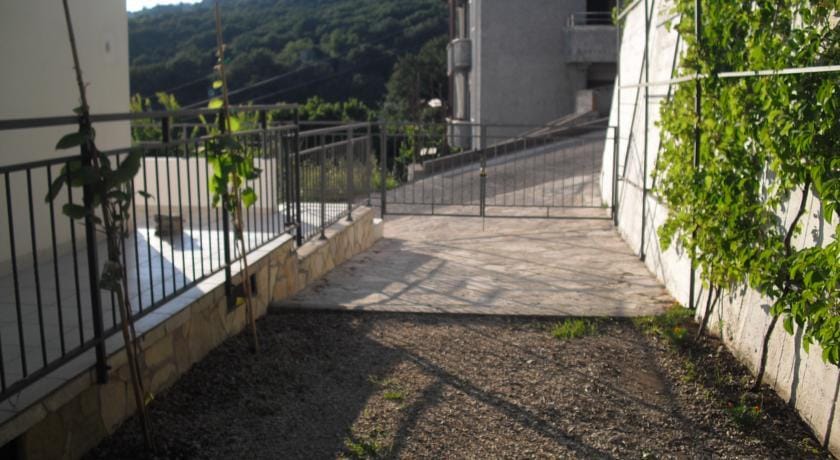 Karadağ, Herceg Novi’deki binanın çevre alanı: taş döşeli alan, çit ve yeşil bitkiler.