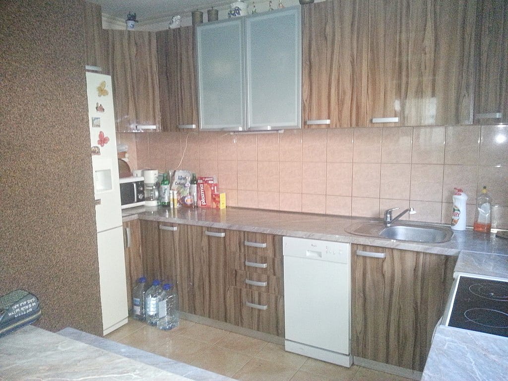 Karadağ, Herceg Novi’deki evde ahşap kapaklı ve ankastre cihazlı mutfak: çalışma alanı ve ocak görünümü.