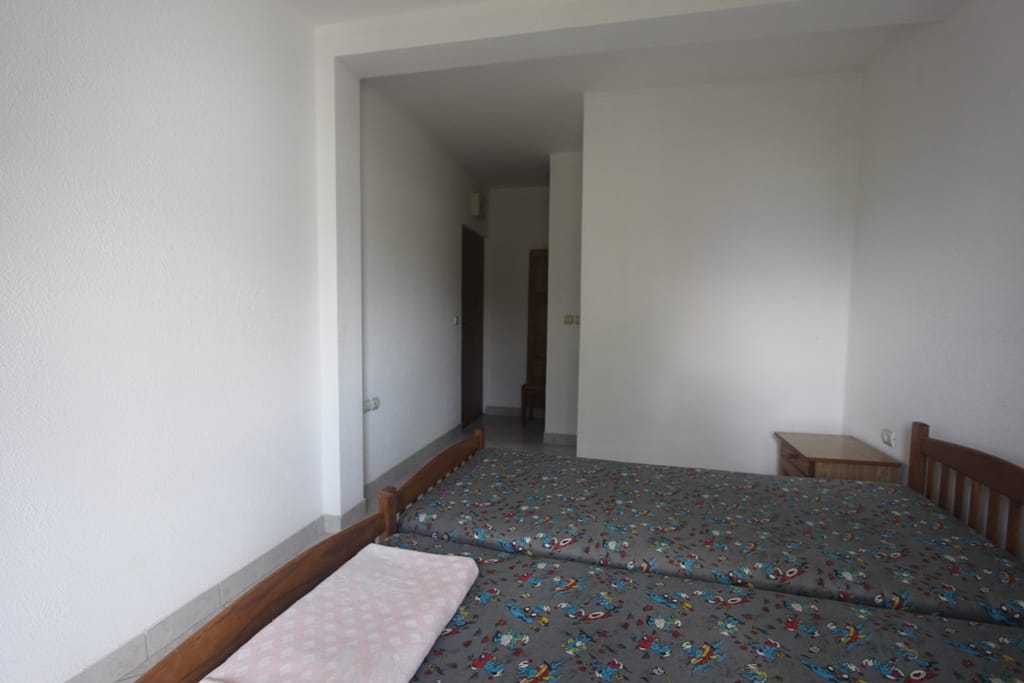 Spavaća soba sa dva odvojena kreveta u mini-hotelu, Baošići, Crna Gora: svetla obrada i drveni nameštaj.
