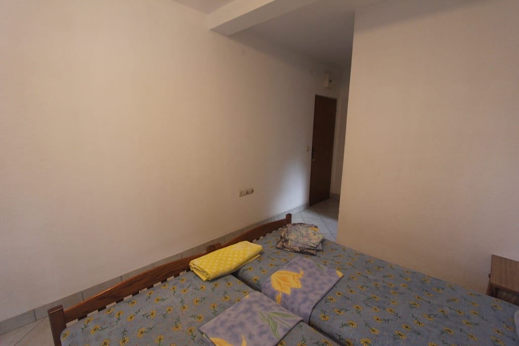 Spavaća soba sa dva odvojena kreveta u mini-hotelu, Baošići, Crna Gora: svetla obrada i drveni nameštaj.