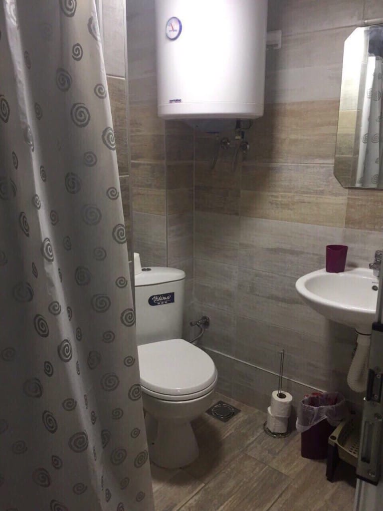 Kupatilo u mini-hotelu, Rafailovići, Crna Gora: pločice, sanitarije Vidima, bojler i tuš zavesa.
