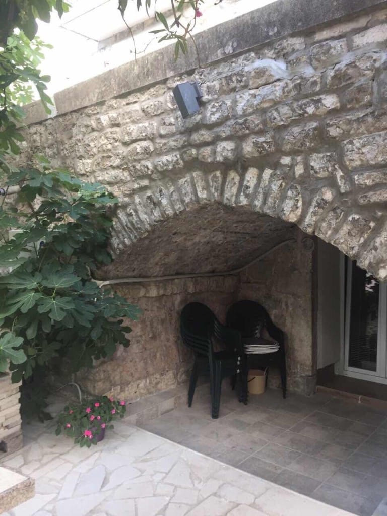 Ugodna terasa sa kamenim lukom i baštenskim nameštajem u mini-hotelu, Rafailovići, Crna Gora.