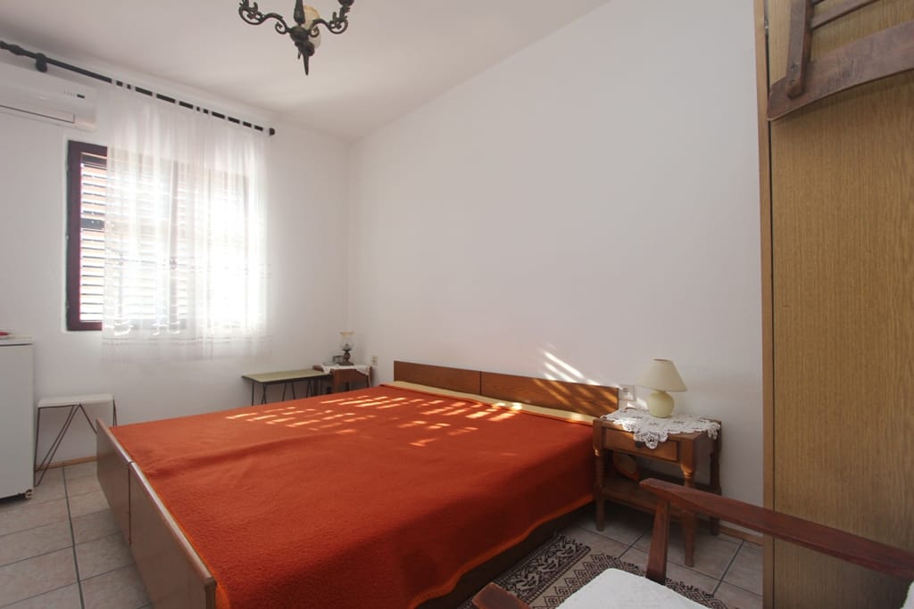 Schlafzimmer mit Doppelbett in einem Haus in Orahovac, Montenegro: heller Raum mit Klimaanlage und Holzmöbeln.