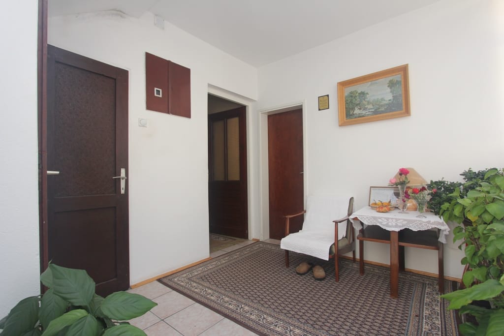 Helle Diele im Haus, Orahovac, Montenegro: Teppich, Holztüren, Sessel und Zimmerpflanzen im Interieur.