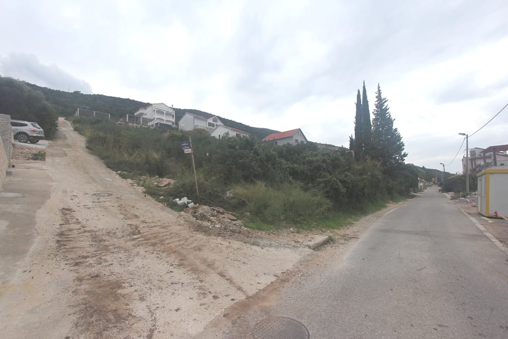 Karadağ, Krašići'de inşaata uygun arsa: giriş yolu ve engebeli arazi yapısına bakış.