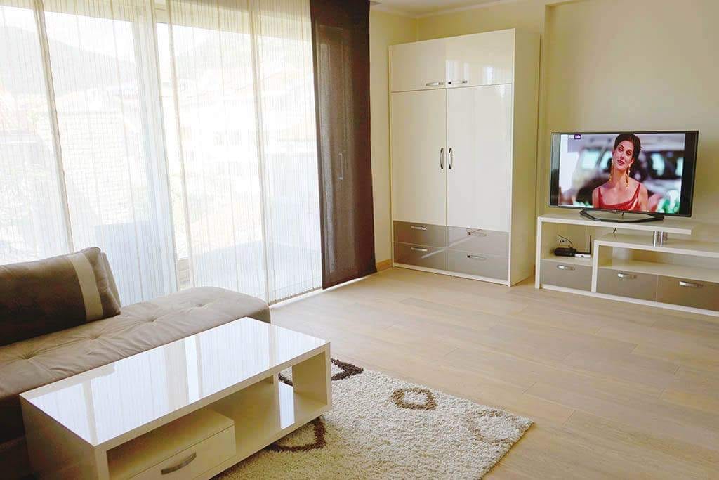 Helles Wohnzimmer mit modernen Möbeln und Panoramafenster in einer Wohnung in Budva, Montenegro.