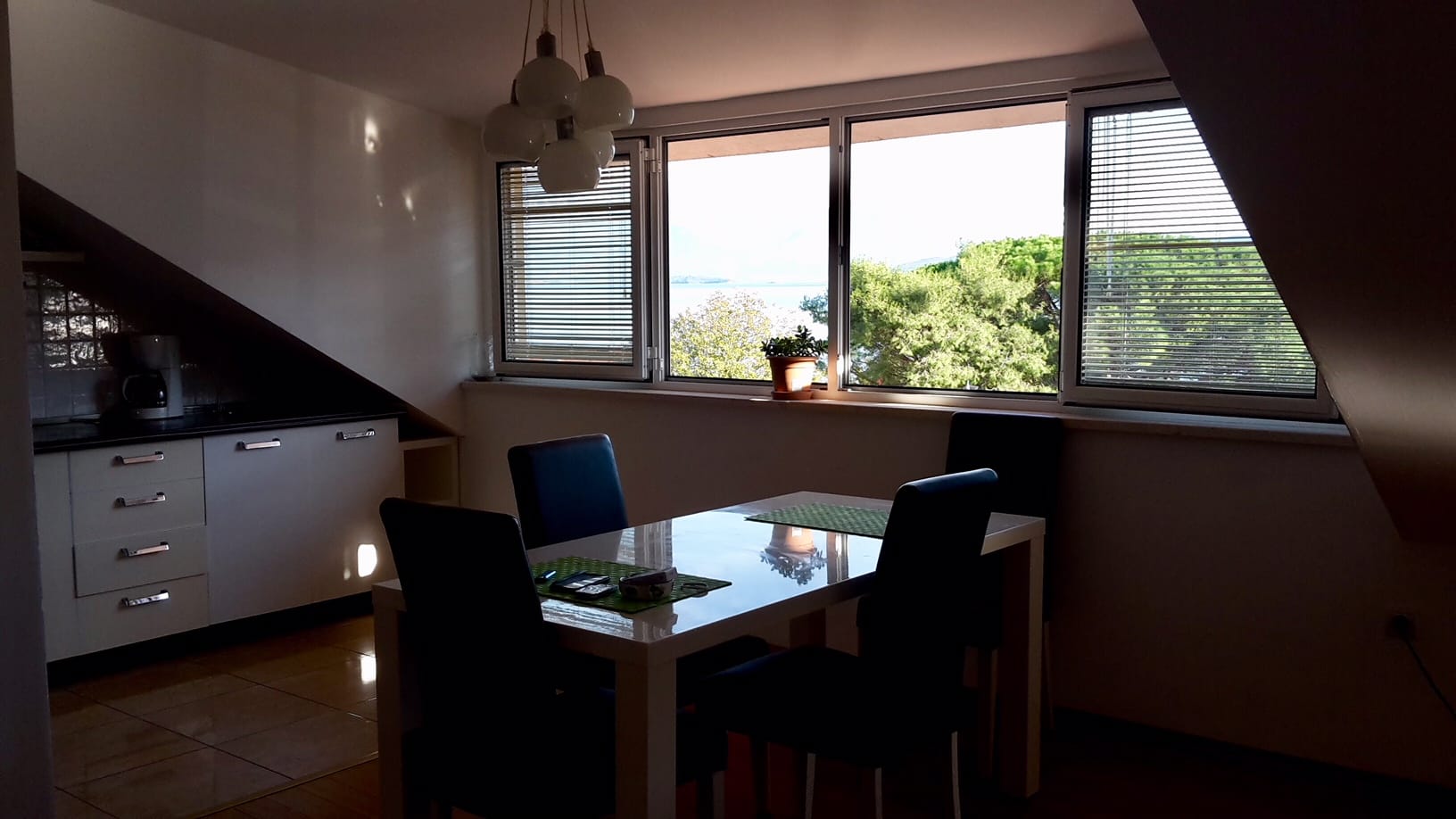 Wohnzimmer mit Essbereich und Meerblick in einer Wohnung, Đenovići, Montenegro: moderne Küche und Panoramafenster.