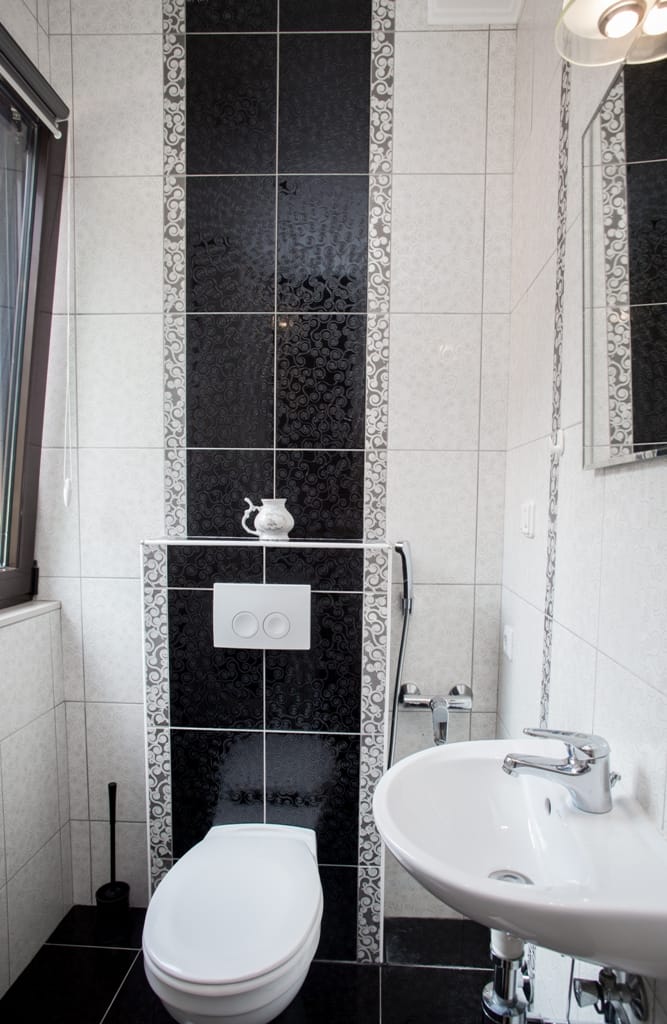 Modernes Badezimmer mit schwarz-weißen Fliesen in einem Haus in Orahovac, Bucht von Kotor, Montenegro.