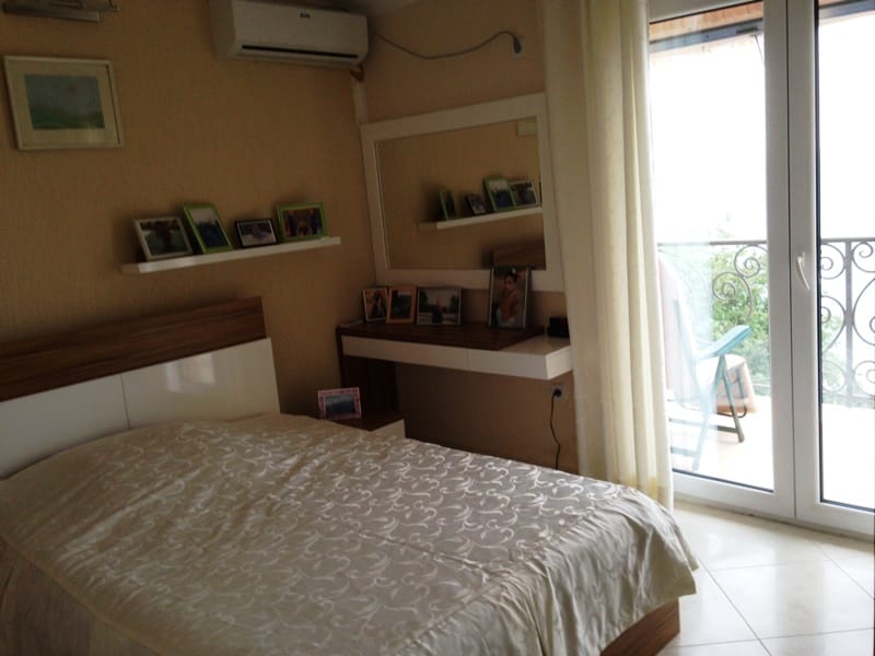 Spavaća soba u kući, Dobri Vode, Crna Gora: bračni krevet, toaletni stočić, izlaz na balkon s pogledom na more.
