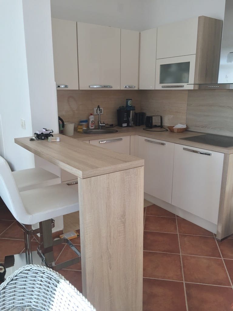 Savremena kuhinja sa barskim pultom i svetlim frontovima u vili u Dobrim Vodama, Crna Gora.