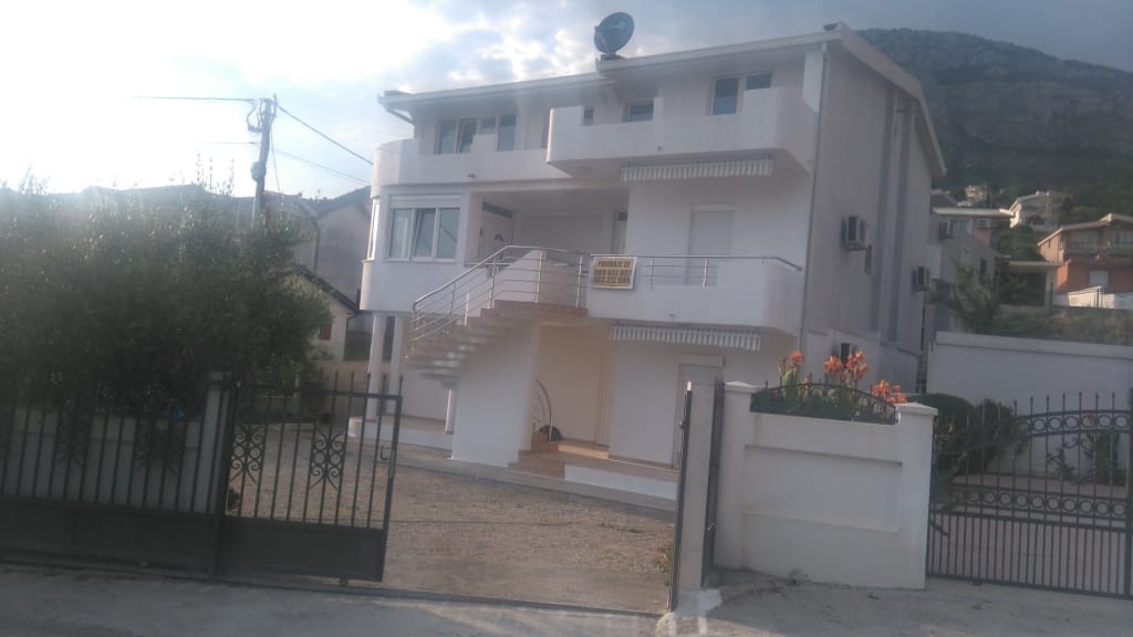 Three-story white house with terraces and an exterior staircase for sale in Shushan, Montenegro, with a fenced plot.