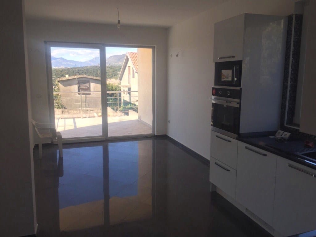Kitchen with modern furniture and access to a terrace with mountain views in a villa in Utjeha, Montenegro.