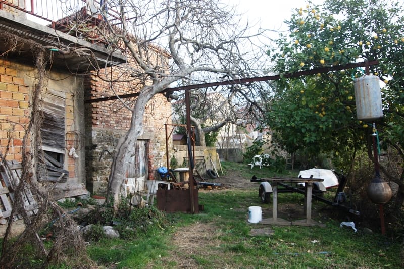 Plac sa kućom za rekonstrukciju i limunovim drvetom u Krašićima, Crna Gora: pogled na dvorište i baštu.