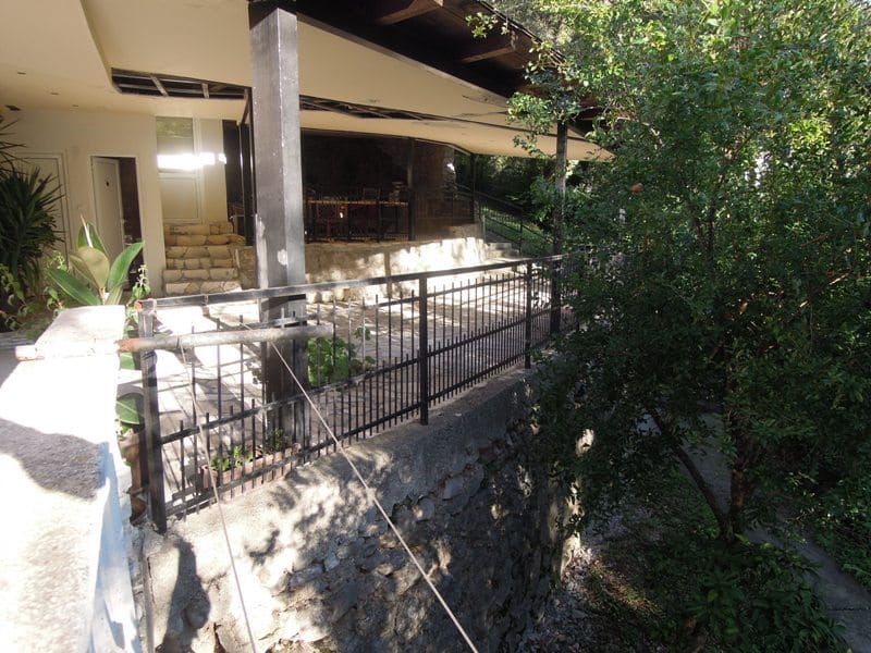 Prostrana terasa sa kamenim oblogama i kovanim ogradama u kući, Bečići, Crna Gora.