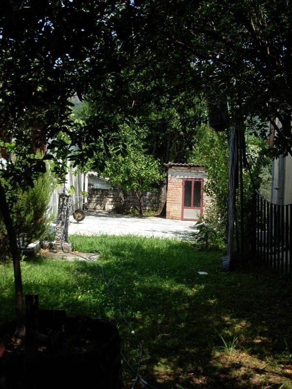 Zelena bašta i zidana građevina na placu privatne kuće u Bečićima, Crna Gora.