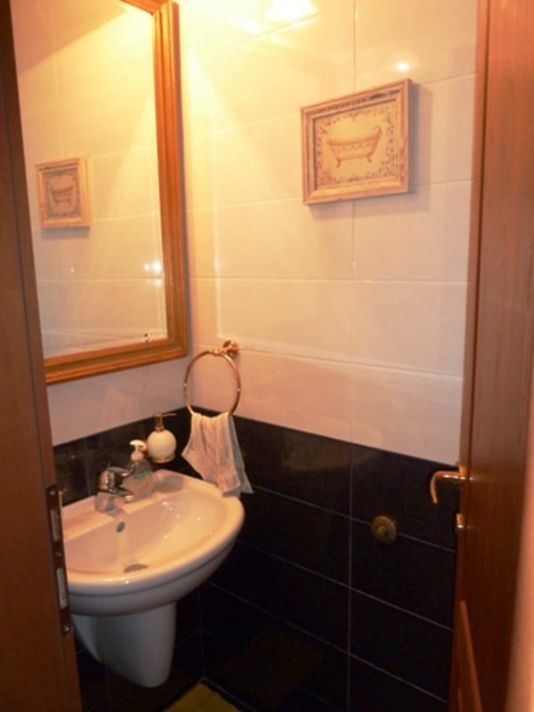 Bathroom with a white sink and mirror in an apartment in Risan, Montenegro: modern tile finish.