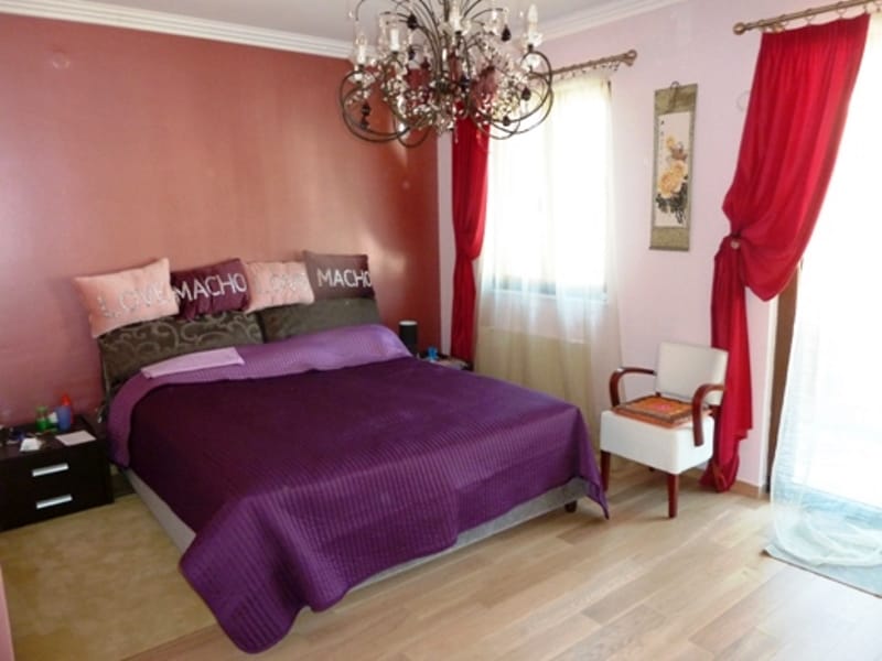 Bedroom with a double bed, a purple bedspread, and a chandelier in an apartment for sale in Risan, Montenegro.