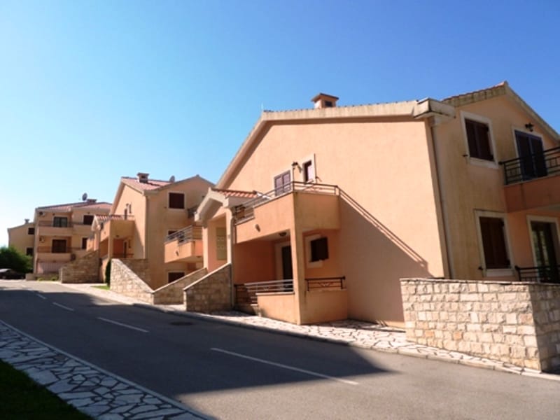Modern residential complex with beige facades and stone finishes in the city of Risan, Montenegro.