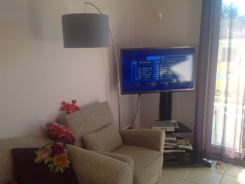 Cozy living room with a TV and armchair in a villa in Shushan, Montenegro: modern interior and panoramic window.