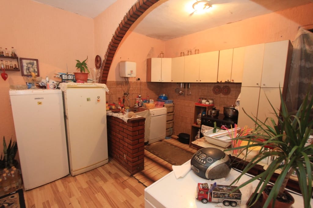 Cuisine avec arche en briques et mobilier clair dans une maison à vendre à Dobrota, Monténégro.