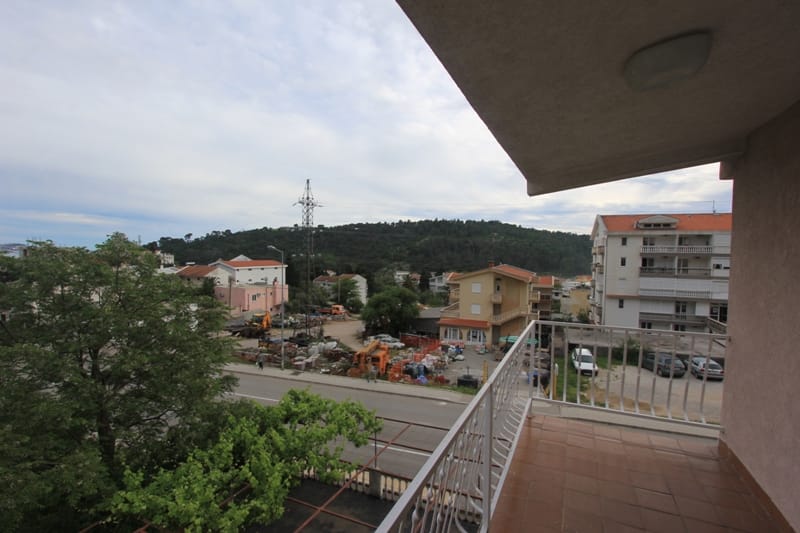 Pogled sa balkona kuće u Sutomoru, Crna Gora: panorama grada, zelene planine i okolna teritorija sa objektima.