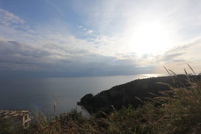 Panoramski pogled na Jadransko more i planine sa zemljišne parcele u Budvi, Crna Gora, u pozadini zalaska sunca.