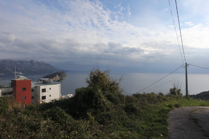 Panoramski pogled na more i planine sa zemljišta u Budvi, Crna Gora, sa pogledom na obalu i modernu vilu.