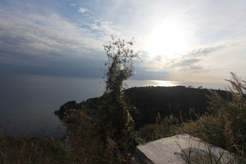 Panoramski pogled na more i obalu sa zemljišta u Budvi, Crna Gora: slikovit pejzaž sa brdima i zalaskom sunca.