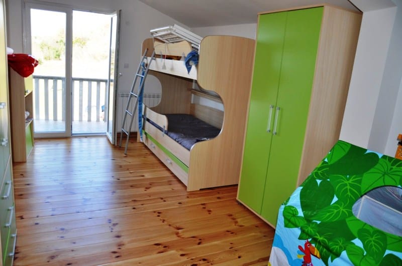 Dečja spavaća soba sa krevetom na sprat i izlazom na balkon u kući na Luštici, Crna Gora. Svetao enterijer.