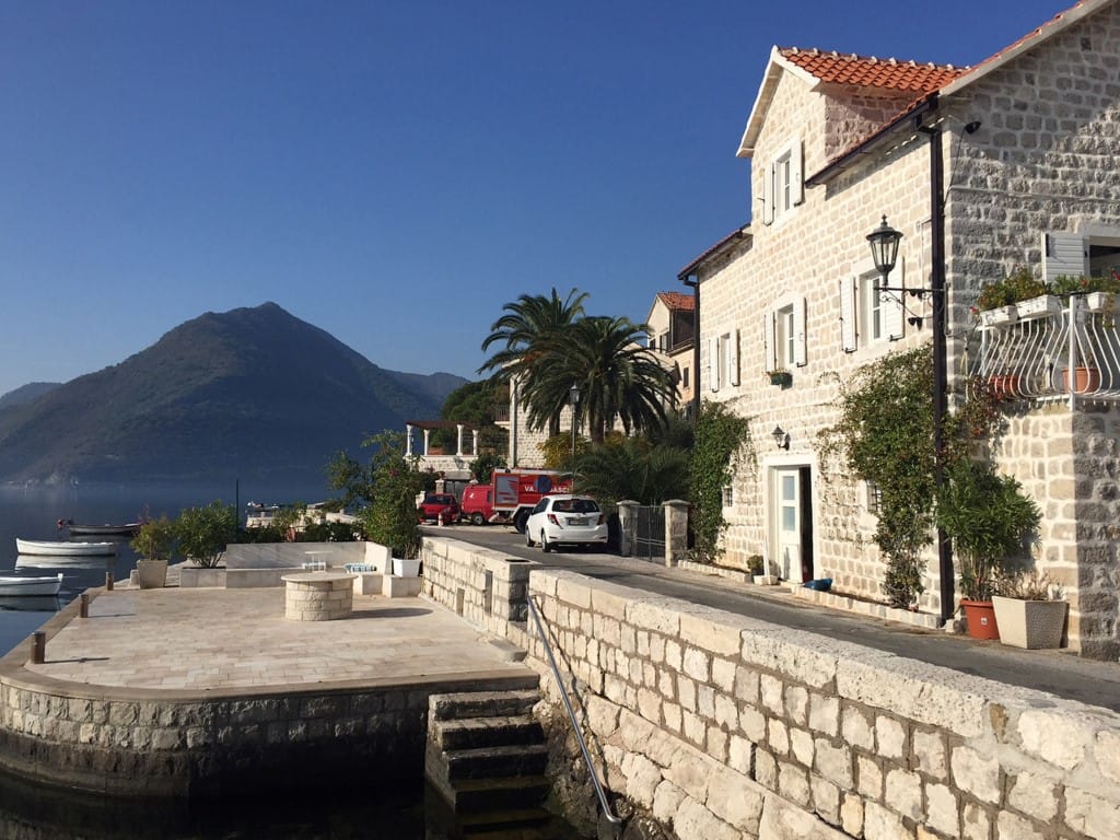 Steinvilla an der Uferpromenade in Perast, Montenegro: Blick auf die historische Fassade, die Terrasse am Meer und die Berglandschaft.