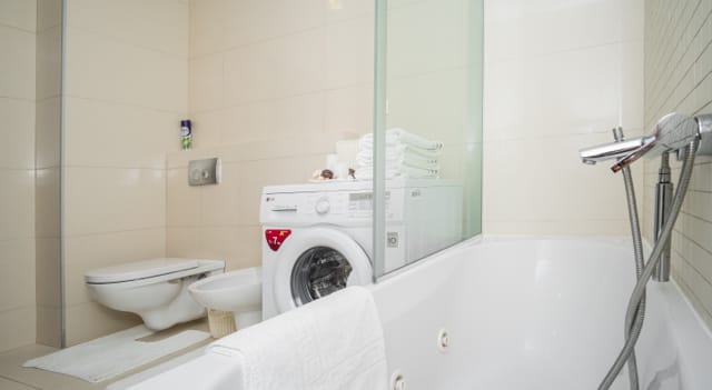 Savremeno kupatilo sa đakuzijem, veš mašinom i sanitarnom opremom u stanu u Budvi, Crna Gora.